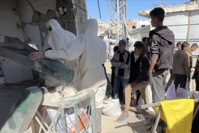 Gazze'de açlık çeken Filistinliler, ellerinde kalan bakliyat ve hububatları öğüterek ekmek yapıyor