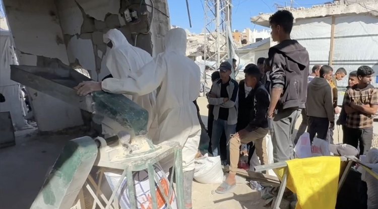 Gazze'de açlık çeken Filistinliler, ellerinde kalan bakliyat ve hububatları öğüterek ekmek yapıyor